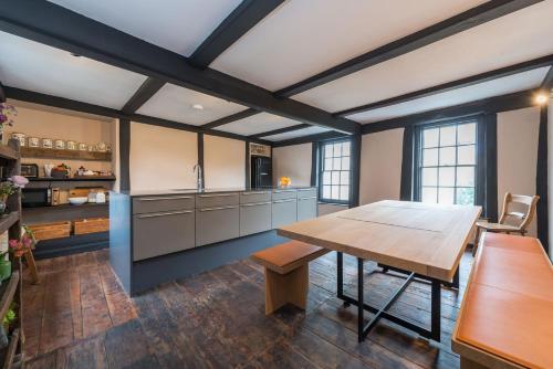 a kitchen with a wooden table and a dining room at The Haven in Sandwich