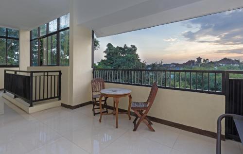 a balcony with a table and chairs and a view at The Paica in Denpasar