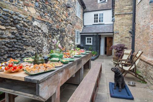 a table with plates of food and a cat sitting on a bench at The Haven in Sandwich