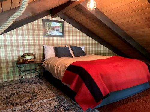 una camera da letto con letto rosso in mansarda di Fantastic Secluded Cabin with Nice Sights in North Creek, New York a North Creek