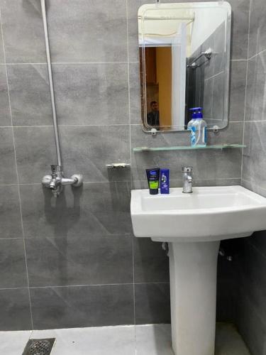 a bathroom with a sink and a mirror at Durrani House in Dargai