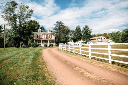 a dirt road in front of a house with a fence at Charming Accommodation for a Weekend Getaway in Buckingham Township, Pennsylvania in Buckingham
