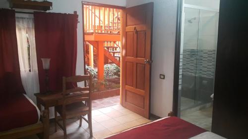 a bedroom with a door and a table and a chair at Hotel El Maltese in Granada