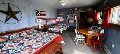 a bedroom with a bed and a desk and a table at Secluded Cottage on East Ash Creek near Fort Robinson State Park, Nebraska in Whitney