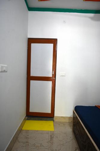 a room with a door and a bed in it at maa kalishila home stay in Ukhimath