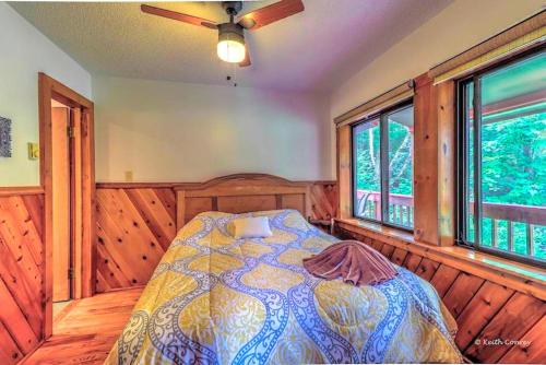 a bedroom with a bed in a room with windows at Cozy and Secluded Cabin with a Fireplace in the Poconos Mountains of Pennsylvania in Canadensis