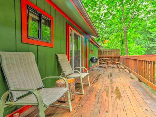 a green house with chairs on a wooden deck at Cozy and Secluded Cabin with a Fireplace in the Poconos Mountains of Pennsylvania in Canadensis