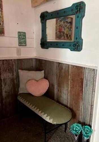 a bench with a heart pillow and a mirror at Tiny Quaint Rental Perfect for a Small Family Escape in Texas in Ledbetter