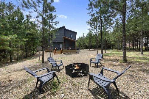 un groupe de chaises autour d'un foyer extérieur devant une cabine dans l'établissement Amazing Secluded Cabin Perfect for Couples in Broken Bow, Oklahoma, à Stephens Gap