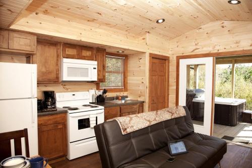 Una cocina con un sofá en una cabaña de madera. en Sublime Cabin with Hot-tub and Fire Pit in Herold, Illinois, en Karbers Ridge