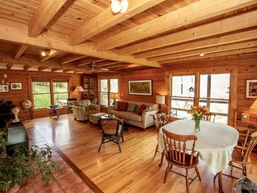 a large living room with a table and chairs at Luxury Log Cabin with 18 Acres of Countryside and Swimming Pond near Athens, Ohio in Athens