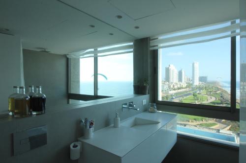 a bathroom with a sink and a large window at Sea Apartment in Netanya