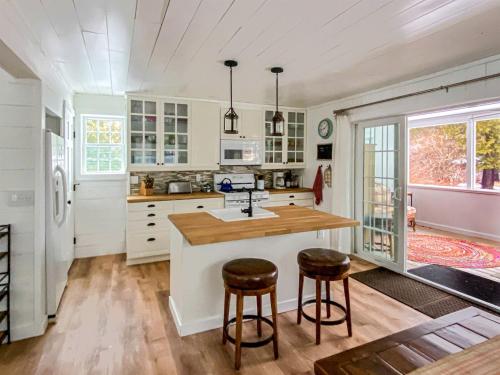a kitchen with white cabinets and a counter with stools at Beautiful Wells Rental Family Vacation in New York in Wells