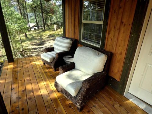 zwei Stühle auf der Veranda eines Hauses in der Unterkunft Inviting Family-Friendly Cabin Rental for Four on Flathead Lake in Montana in Lakeside