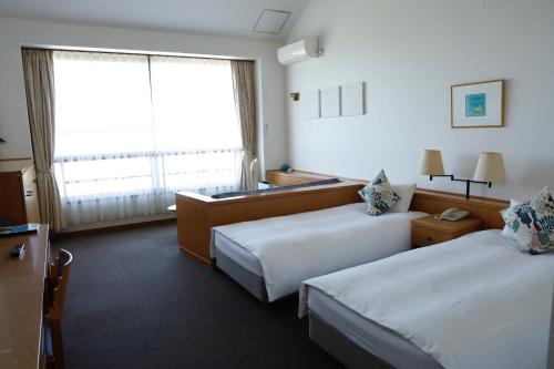 a hotel room with two beds and a window at DokiDoggie館山DIANA in Tateyama