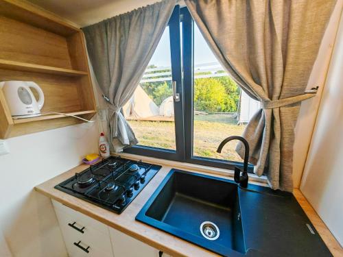 a small kitchen with a sink and a window at Pura Vida Downtown Tiny houses in Bucharest