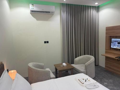 a waiting room with chairs and a television and a table at شقق دفادف المخدومة in Hail