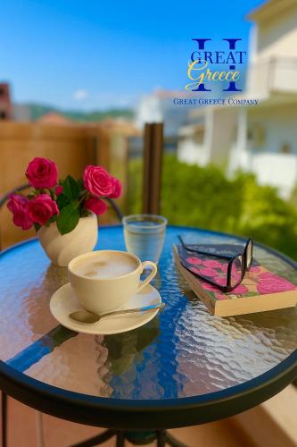 a table with a cup of coffee and a book and glasses at Great Greece Le Convivial Suites in Xylokastron