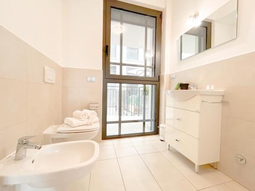 a white bathroom with a sink and a toilet at 35 - Casa a due passi Dal mare Terrazza - Wifi - AC in Savona