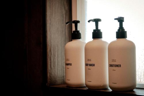 a group of three shampoo bottles sitting on a shelf at Magical Tennessee Tiny House with a Rooftop Deck in Alcoa