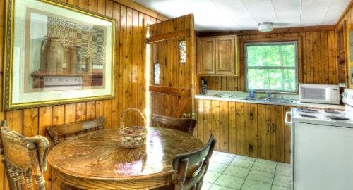 a kitchen with a wooden table and a dining room at Deluxe Cabins for Rent near Lake Cumberland in Somerset, Kentucky in Bronston