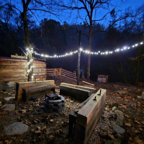 a lit up yard with a fence and lights at Remote Mountain A-Frame with BBQ Perfect for Nature Lovers in West Virginia in Malden