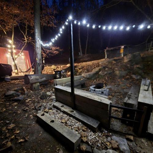 a park with a bunch of lights and benches at Remote Mountain A-Frame with BBQ Perfect for Nature Lovers in West Virginia in Malden