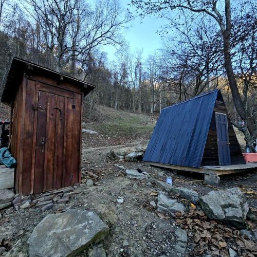 a small wooden out house with a blue roof at Remote Mountain A-Frame with BBQ Perfect for Nature Lovers in West Virginia in Malden