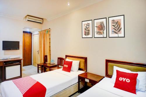 a hotel room with two beds and a television at OYO 94799 Siwah Hotel in Banda Aceh