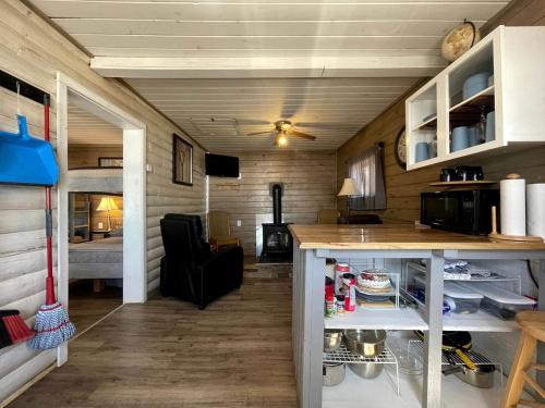- une cuisine et un salon dans une petite maison dans l'établissement Portage Lakeside Cabins in Portage Lake, ME, à Portage Lake Municipal Seaplane Base