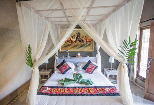 a bedroom with a bed with a canopy at Global Lodge Pemuteran in Pemuteran