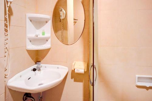 a bathroom with a sink and a mirror at OYO 94799 Siwah Hotel in Banda Aceh