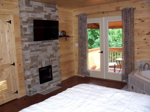 a bedroom with a stone fireplace and a television at Mammoth Cave Cabin for the Best Holiday in Kentucky in Mammoth Cave
