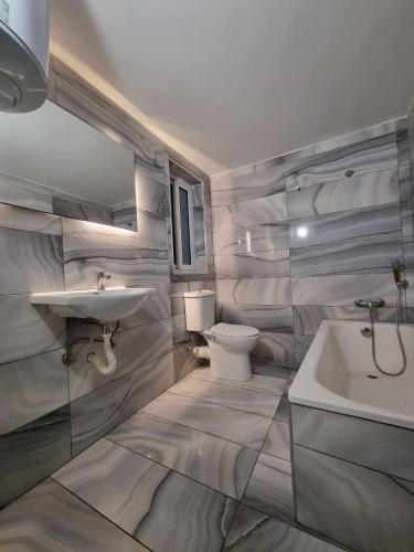 a white bathroom with a sink and a toilet at Stay by the Grand Harbour of Valletta in Senglea