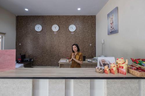 a woman standing behind a counter in a store at Capital O 94770 Hotel Astra Novilia in Makassar