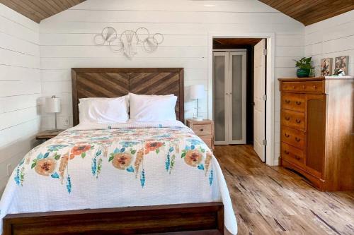 a bedroom with a bed with a floral bedspread at Entire Three Cabins Property Perfect for Big Groups in Marion, Illinois in Sunset Harbor