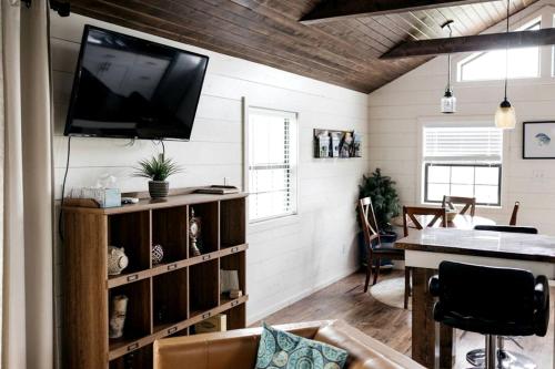 a living room with a television on a wall at Entire Three Cabins Property Perfect for Big Groups in Marion, Illinois in Sunset Harbor