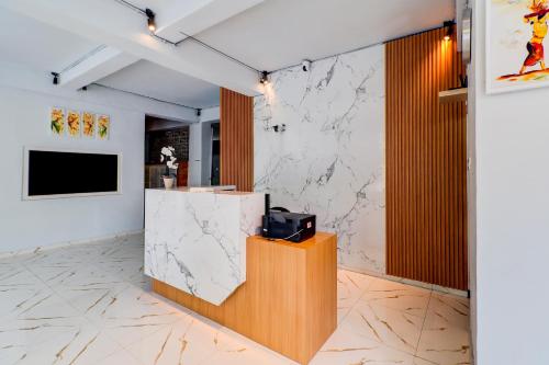 a lobby with a counter and a tv on a wall at Townhouse Oak @lebak Bene Near Kuta Beach in Legian