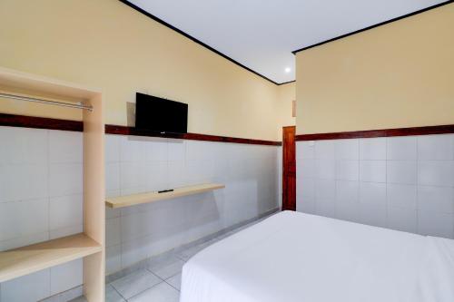 a bedroom with a bed and a tv on the wall at Townhouse Oak @lebak Bene Near Kuta Beach in Legian