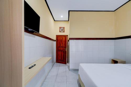 a bedroom with a bed and a bath tub at Townhouse Oak @lebak Bene Near Kuta Beach in Legian