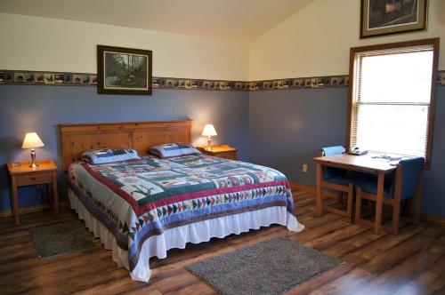 a bedroom with a bed and a table and a desk at Charming Cabin by the Umpqua River Perfect for an Outdoor Getaway in Oregon in Elkton