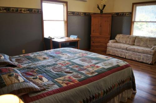 a bedroom with a bed with a quilt on it at Charming Cabin by the Umpqua River Perfect for an Outdoor Getaway in Oregon in Elkton