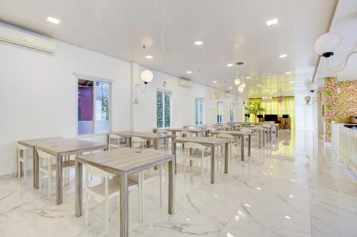 a row of tables and chairs in a room at Capital O 94792 Aleander Hotel in Jakarta
