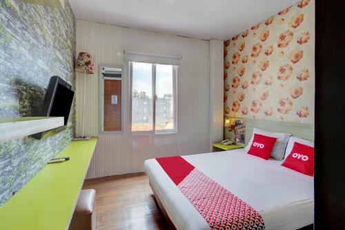 a hotel room with a bed and a window at Capital O 94792 Aleander Hotel in Jakarta