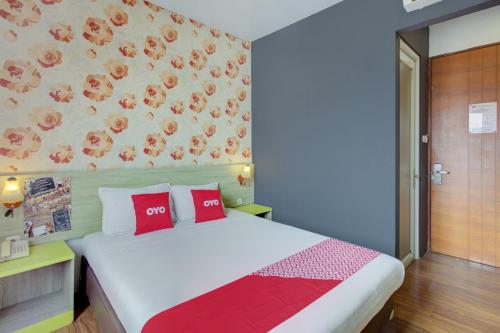 a bedroom with a large bed with red pillows at Capital O 94792 Aleander Hotel in Jakarta