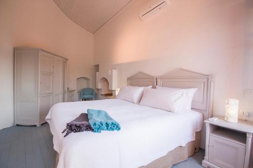 a bedroom with a white bed with a blue towel on it at The Old Markets in Symi