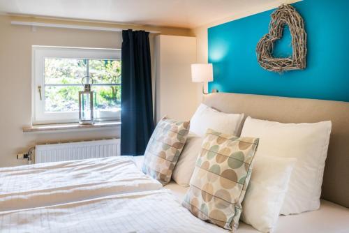 a bedroom with blue walls and a bed with pillows at Hotel kleine Auszeit - Adults Only in Sankt Peter-Ording