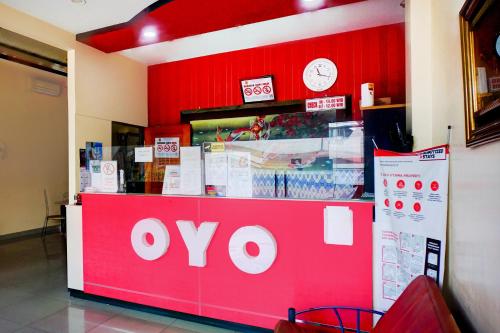 a store with a red and white counter with a clock at OYO 94787 Hotel Mulana in Banda Aceh