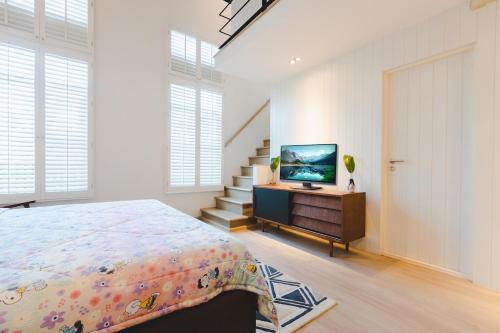 una camera con letto e TV su un comò di Beautiful private house 