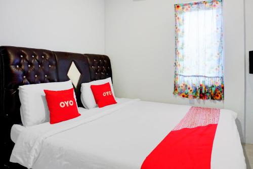 a bedroom with a bed with red pillows at OYO 94787 Hotel Mulana in Banda Aceh